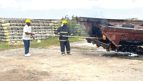 Godwin Edudzi Tamekloe (left), Chief Executive Officer of NPA, and a fire expert setting fire to the boats
