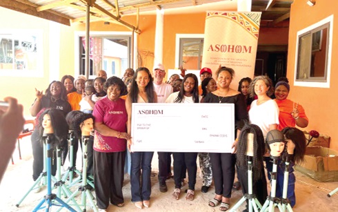 Sovanna Taliercio (2nd from left), President, ASOHOM, presenting a dummy cheque to Abena Washington (3rd from right), Director of Chosen Rehab