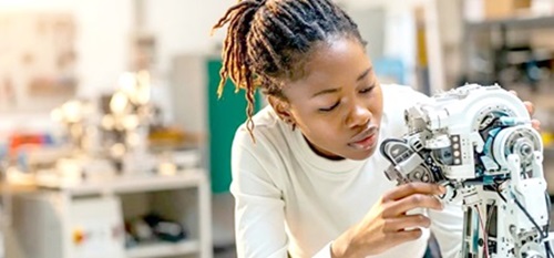 A female inspecting the arm of a robotic AI