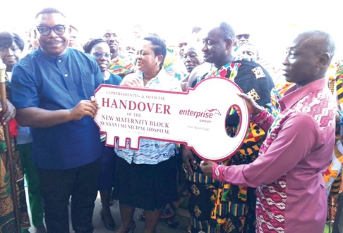 Mike Tyson (right), Chief Financial Officer of Enterprise Group PLC, presenting the symbolic key to Dr Richard Adinkrah-Kyeremeh, Sunyani Municipal Director of Health Services