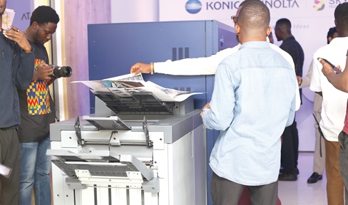 Some participants in the launch examining materials printed by the machine.