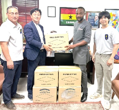 Rev. David Choi (2nd from left), Managing Director of Mission International School, presenting the donated sports tapes to Jerry Ahmed Shaib, President of the Ghana Weightlifting Federation, assisted by staff of the school