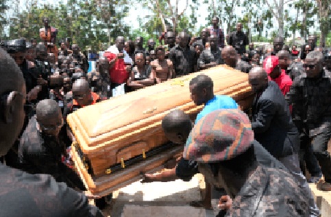Mourners around a casket being lowered