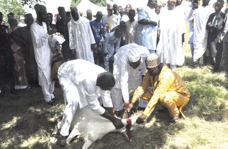 Alhaji Ali Mohamed (middle), the officiating Imam, slaughtering the ram