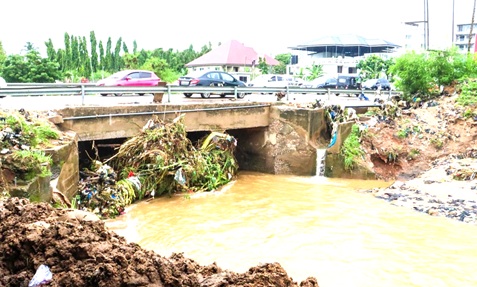 The drainage system under the Dome bridge blocked by waste materials, disrupting the natural flow of the Odaw River