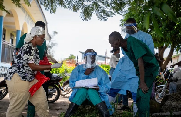 A health worker shows his colleagues a list of patients at Rwampara Hospital in Ituri, in the eastern Democratic Republic of the Congo