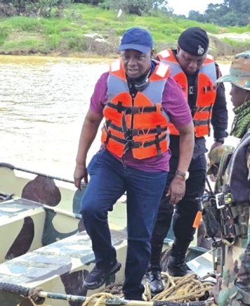 Emmanuel Armah Kofi Buah (front) with some military personnel on a tour of River Ankobra River to combat illegal mining