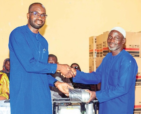 Dr Mahama Tia Abdul-Kabiru(left), NPP MP for Walewale presenting pump machines to a farmer to support dry season farming