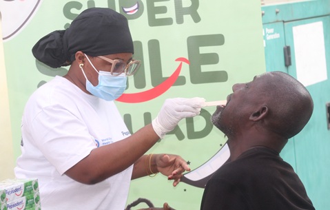 Priscilla Ameyaw (left) from Serepa Dental Clinic examining a beneficiary