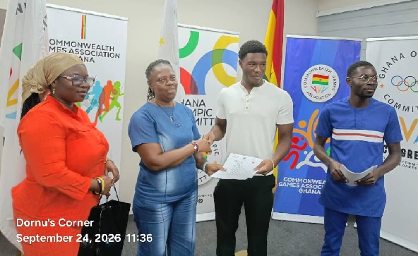    Delphina Quaye, GSA President handing over the scholarship to Ivan Snowden while other officials look on