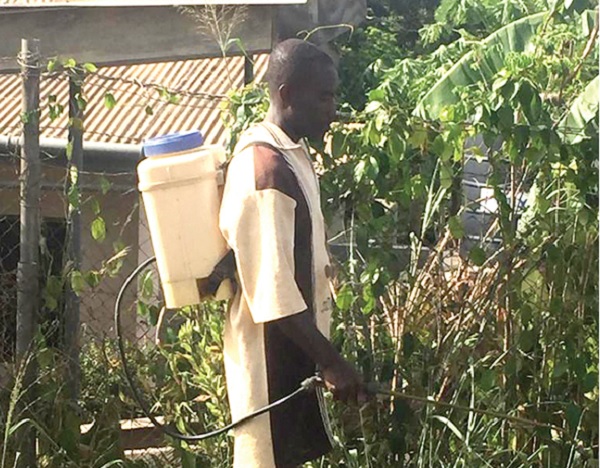 A man spraying without wearing protective clothes