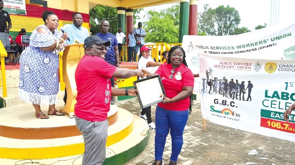 Seth Kwame Acheampong (left), Eastern Regional Minister, presenting a citation to Agnes Amoako, one of the workers who were presented with prizes for their hard work Seth Kwame Acheampong (left), Eastern Regional Minister, presenting a citation to Agnes Amoako, one of the workers who were presented with prizes for their hard work