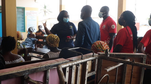 Mrs Audrey Boham, Administrative Manager of the Teshie Community Clinic taking staff of The Coca-Cola Bottling Company of Ghana Limited on a tour of the clinic
