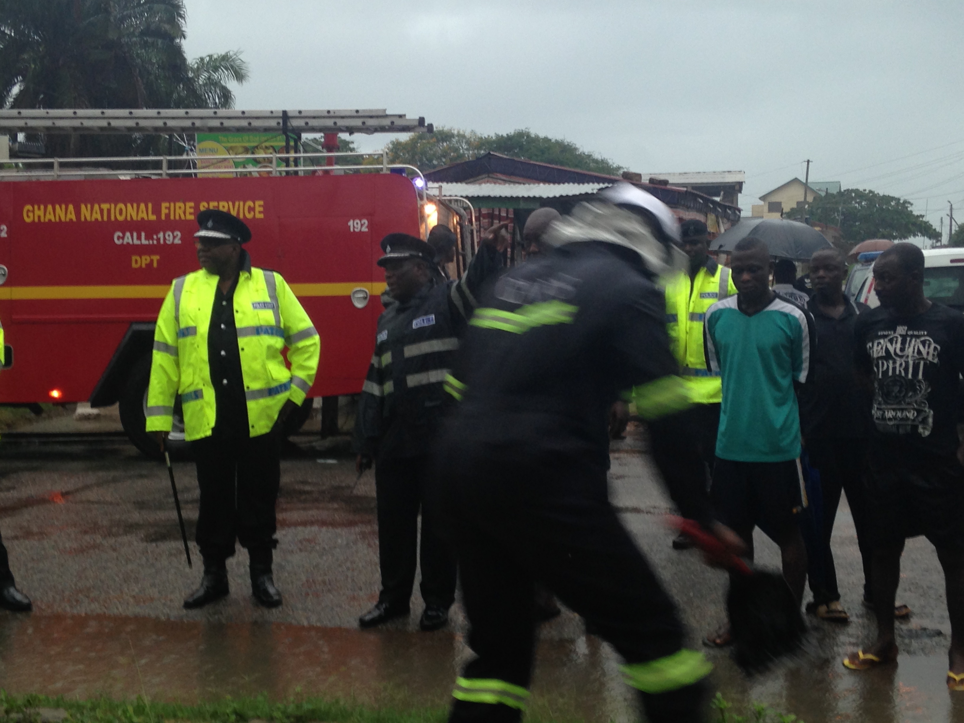 Inspector General of Police Mohammed Ahmed Alhassan looks on as crews clear the gutters