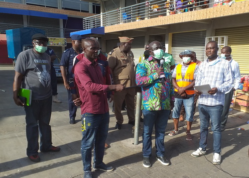 Nii Adjei Tawiah (with mic) speaking to the treaders at the CMB market