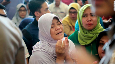 A relative of passengers prays as she and others wait for news on the Lion Air plane.
