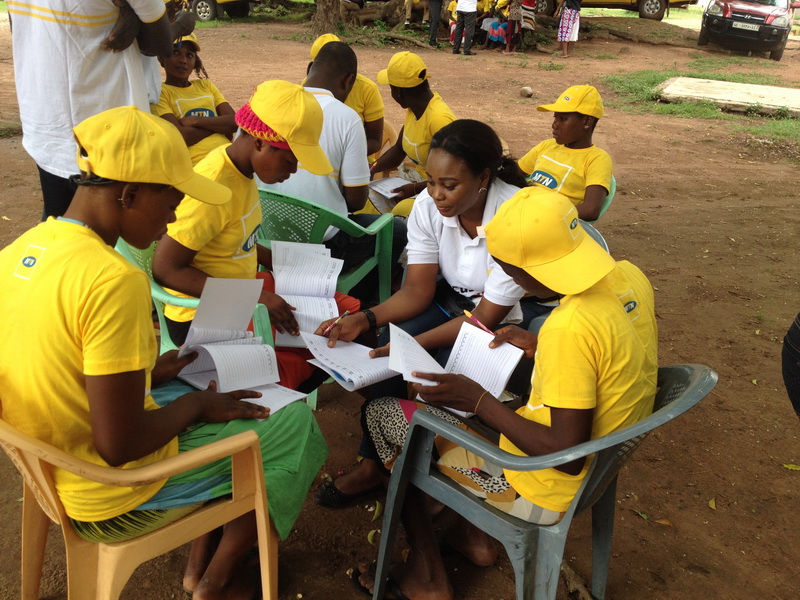 An MTN volunteer teaches some Kayayeis basic writing