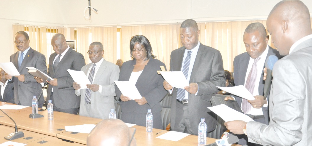 Mr Haruna Iddrisu (right) administering the oath of office to members of the new board of ADB