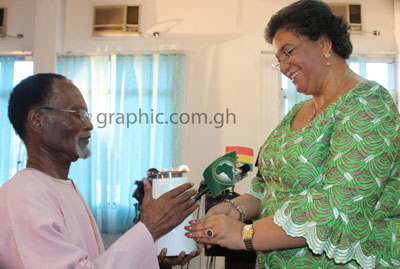 Hanna Tetteh (R) handing over the anniversary torch to Prof. Atukwei Okai