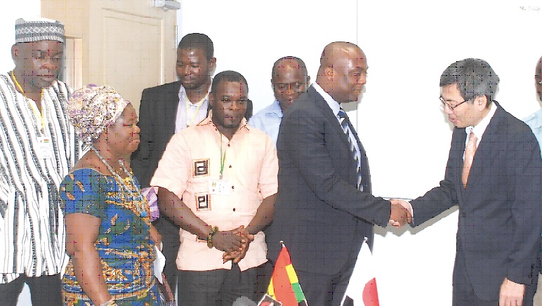 Mr Thomas Ampem-Nyarko (2nd right), the DCE, Asuogyaman District Assembly, in a handshake with Mr Naoto Nikai after signing the grant contract in Accra. Looking on are members of the assembly and Nana Ohenewaa I (2nd left), Queenmother of Dodi-Asantekrom.