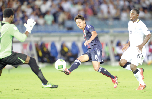 Japan midfielder Hiioshi Kiyotake shoots at Ghana goalie Razak Braimah as defender Kissi Boateng (right) closes in to support. Picture: Getty Images