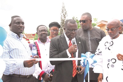  Rev. Dr Paul Kofi Fynn, President of Wisconsin International University College (middle), being assisted by Chief Godfred Medicine (left) and Rev. John Ben Tay to open the business centre. INSET:  The new US Business Complex