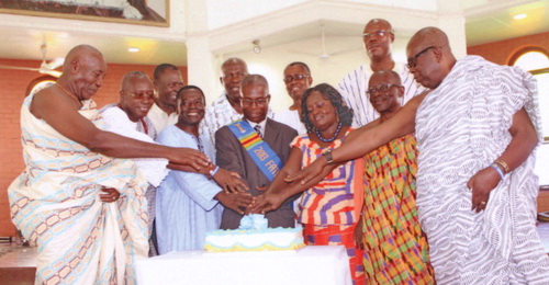 Mr Louis Asiatorme, the Father of the Year (middle) and Mrs Asiatormey (fourth from right) are joined by previous Fathers of the Year, to cut the celebration cake.