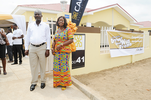 Proud house owner, Ms Ernestina Owusu-Sekyere and her husband, Mr George Appiah pose in front of the two-bedroom house.