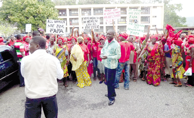 Some demonstrators clad in red apparel holding placards.