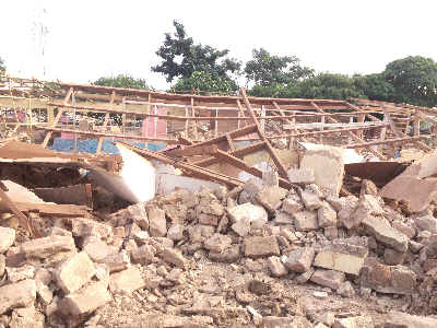  Debris of the structures that were demolished. INSET: School furniture and some books exposed to the weather after the Tamale Metropolitan Assembly School building had been demolished.