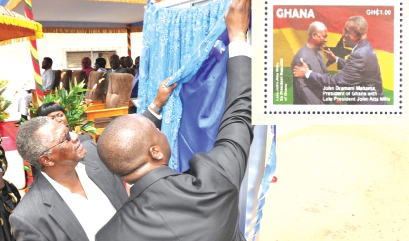 Dr Cadman Mills (left ), brother of the late President Mills being assisted by Dr Edward Omane-Boamah to unveil the commemorative stamps.
