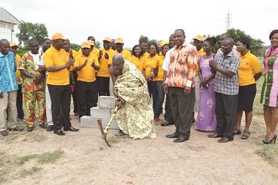 Nene Kwaku Dapo cutting the sod for the take off of the project. Looking on is  the MD of Agapet,  Mr Emmanuel Abledu (left), and the  District Coordinating Director of Ningo-Prampram Assembly, Mr Samuel Andoh–Owusu (right)  Also in the picture is the District Health Director of Ningo–Prampram District,  Mrs Gifty Ofori Ansah. (right in cloth). 