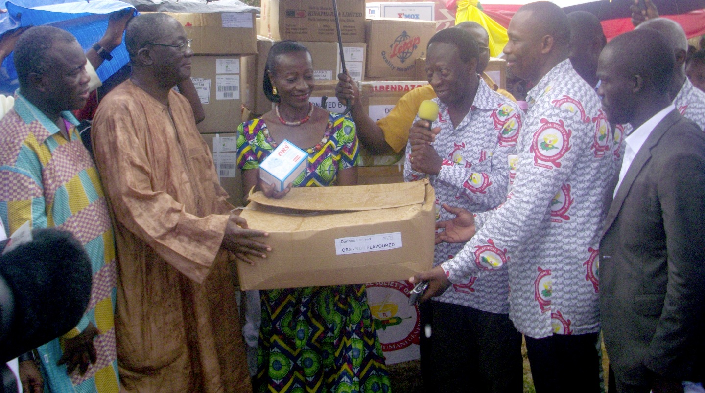 The President of the Pharmaceutical Society of Ghana (PSG), Pharmacist James Ohemeng Kyei (third right) handing over the drugs to Ms Sherry Ayittey (middle). Wth them are other dignitaries who were at the ceremony.