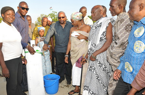 President Mahama turning the tap on as the people look on.