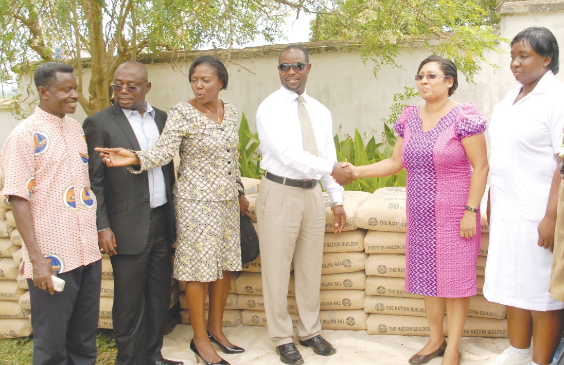 Mr Rudolf Berkley (left), Chief Executive Officer of DVLA, handing over the quantity of bags of cement to Ms Jacqueline Sfarijlani, acting Director of Ga South Directorate of Health Services, at a ceremony at Weija in Accra.