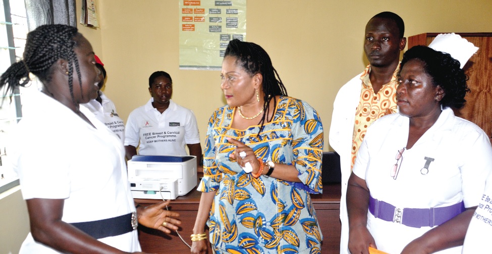 Mrs Faustina Asamoah (left), Nurse in charge of Prevention of HIV/AIDS from Mother to Child Unit of the Sunyani Regional Hospital, briefing the First Lady during the launch of the Lordina Foundation at the Sunyani Regional Hospital in Sunyani.