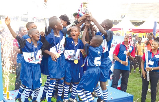 Players of Kotobabi Five Primary School celebrating with their trophy. 