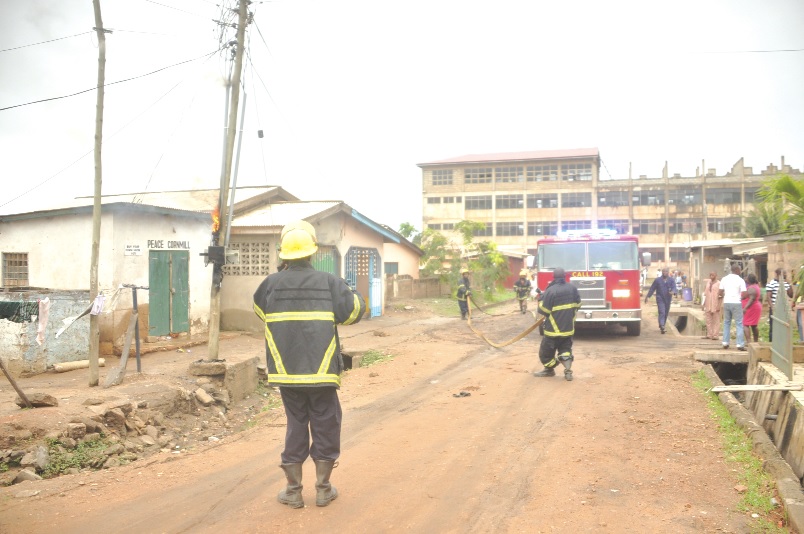 Personnel of the Ghana National Fire Service taking position to put out the fire.