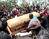 Mourners around a casket being lowered