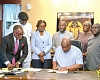 President John Dramani Mahama (seated) signing the documents. Looking on are some government officials