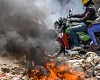 Nearby roads were blocked by piles of burning rubbish and littered with rocks