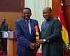 President Mahama (right) handing over the Scroll of Office to Dr Johnson Asiama, Governor of the Bank of Ghana, after swearing him in 