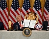 President Donald Trump holds up a document creating the White House Task Force on the FIFA World Cup 2026 as Vice President JD Vance and FIFA president Gianni Infantino look on