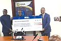 Alex Apau Dadey (right), Executive Chairman, KGL Group, presenting a dummy cheque to Anthony Kwasi Sarpong (middle), Commissioner-General, Ghana Revenue Authority