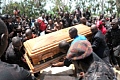 Mourners around a casket being lowered