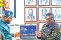 Samuel Nartey George (right),  Minister of Communication, Digital Technology and Innovations; and Mohammed Adams Sukparu, Deputy Minister of Communication, Digital Technology and Innovations, displaying one of the laptops