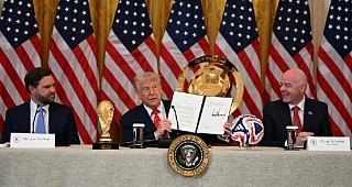 President Donald Trump holds up a document creating the White House Task Force on the FIFA World Cup 2026 as Vice President JD Vance and FIFA president Gianni Infantino look on