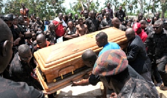 Mourners around a casket being lowered