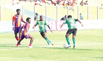 • Kotoko’s Lord Adamu traps the ball as Hearts markers close in on him during the game yesterday
