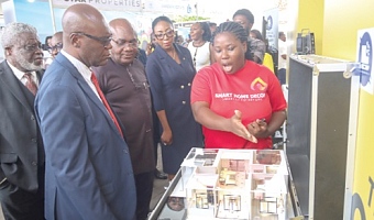 Richeal Naa Quarley Quartey (right), Sales Consultant, Smart Home Decor, explaining a point to Dr James Orleans-Lindsay (2nd from left), President, Ghana Real Estate Developers Association; Samuel Essel (left), Director Finance, GCGL, and some dignitaries during the Daily Graphic-GREDA Home Fair 2025. Pictures: ELVIS NII NOI DOWUONA
